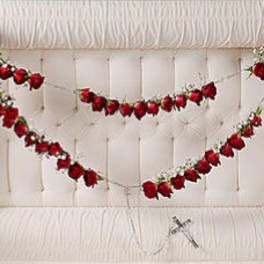 Red rose garlands draped across a white tufted headboard