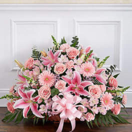 Large pink floral arrangement with lilies, roses, and daisies in a basket