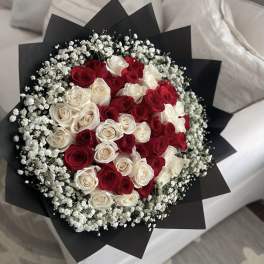 Bouquet of red and white roses wrapped in black paper