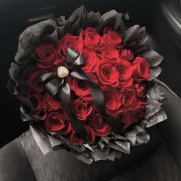 Bouquet of red roses wrapped in black paper with a black ribbon