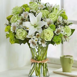 Green and white bouquet in a clear glass vase