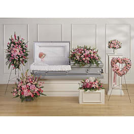 Pink floral funeral casket spray with matching standing wreaths and arrangements