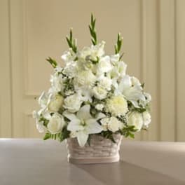 White floral arrangement in a woven basket vase