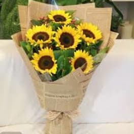 Bouquet of yellow sunflowers wrapped in brown paper
