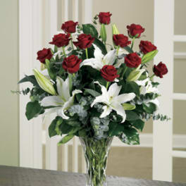 Red roses and white lilies arranged in a clear glass vase