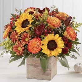 Autumn floral arrangement with sunflowers, roses, and mums in a wooden box