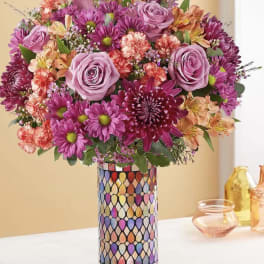 Bouquet of pink and purple flowers in a patterned vase
