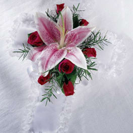 Pink lily and red rose boutonniere on white fabric