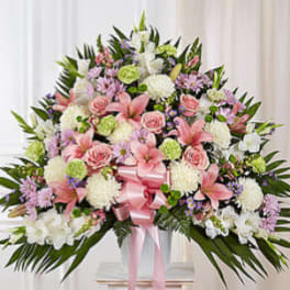 Large pink and white floral spray with a pink ribbon on a stand