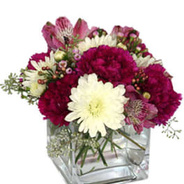 Pink and white mixed bouquet in a clear square vase