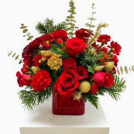 Red roses and red chrysanthemums in a red glass vase with gold accents