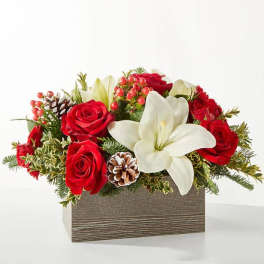 Red roses and a white lily arranged in a rectangular box