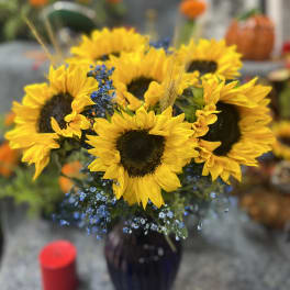 Bouquet of yellow sunflowers in a dark vase
