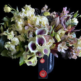 Bouquet of white and lavender flowers in a dark vase