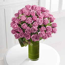 Pink roses arranged in a tall glass vase