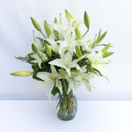 White lilies arranged in a clear glass vase