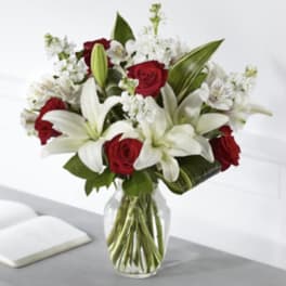 Red roses and white lilies in a clear glass vase