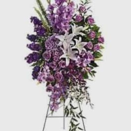 Tall purple and white funeral spray on a stand