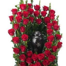 Red roses arranged around a black urn-shaped vase
