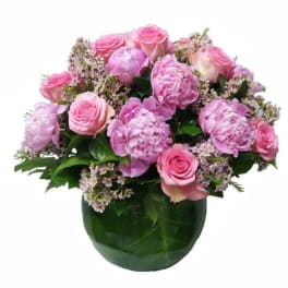 Pink roses and peonies in a green glass vase