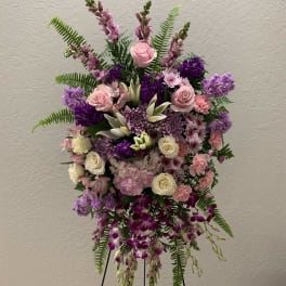 Tall floral spray with pink, purple, and white blooms on a stand