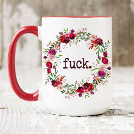 White mug with red handle and floral wreath around text
