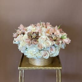 Blush and white floral arrangement in a gold round box