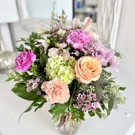 Bouquet of pink and peach flowers in a clear glass vase