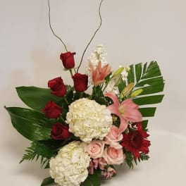 Floral arrangement with red roses, pink lilies, and white hydrangeas