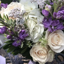 Bouquet of white roses, hydrangea, and purple flowers