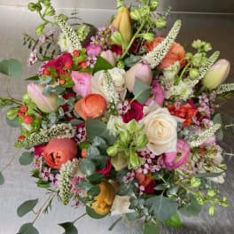 Mixed bouquet of roses, tulips, and ranunculus in pink, white, and peach