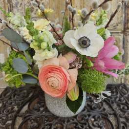 Mixed bouquet in a gray vase with pink, white, and yellow blooms