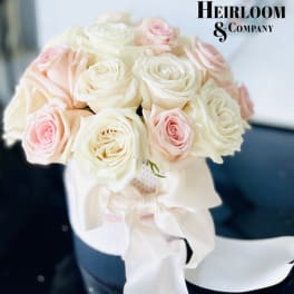 Bouquet of white and blush roses tied with a white ribbon