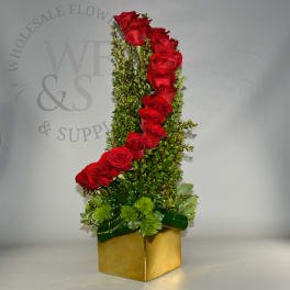Tall arrangement of red roses with greenery in a gold box