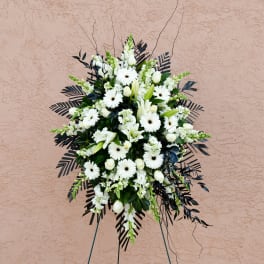 White funeral spray with daisies and lilies on a stand