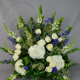 White hydrangeas and roses with blue flowers in a large arrangement
