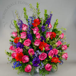 Bright mixed bouquet of pink roses, purple flowers, and orange blooms