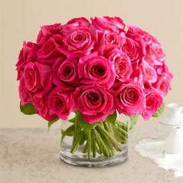 Bright pink roses arranged in a clear glass vase