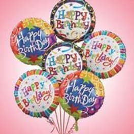 Cluster of colorful Happy Birthday balloons on a pink background