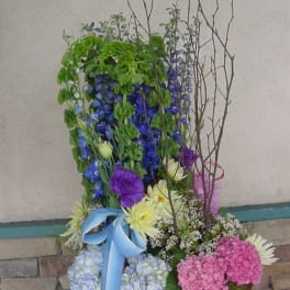 Tall mixed flower basket with blue, pink, and white blooms