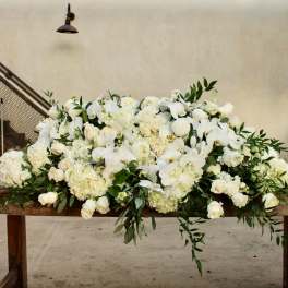 Large white floral arrangement on a wooden table