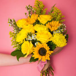 Yellow bouquet with roses, sunflowers, and mums tied with a striped ribbon