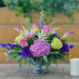 Mixed bouquet in a glass vase with pink, purple, and green blooms