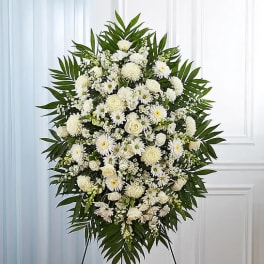 White funeral spray with daisies and roses on a standing easel