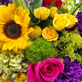 Bright mixed bouquet with sunflowers, yellow and pink roses, and purple blooms
