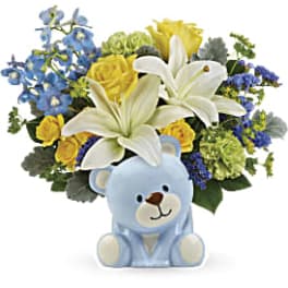 Blue teddy bear with a mixed bouquet of lilies and blue flowers