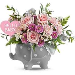 Pink roses and purple flowers in a gray elephant planter with a "Hello Baby" sign