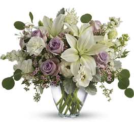 Lavender roses and white lilies in a clear glass vase