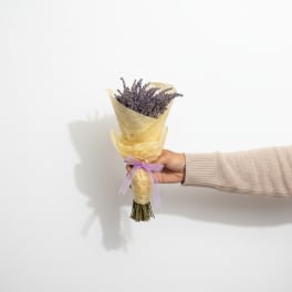 Small lavender bouquet wrapped in yellow paper with a purple ribbon