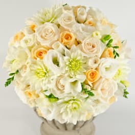 Cream and peach bouquet of roses, dahlias, and calla lilies in a vase